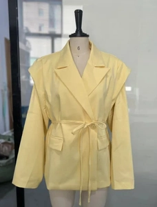 Detailansicht des hellgelben Blazers mit schmalem Bindegürtel und klassischem Reverskragen