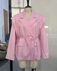 Detail eines rosa langärmeligen Blazers mit Gürteltaille und klassischem Reverskragen