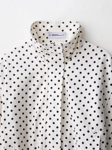 Detailed view of white polka dot jacket collar with internal brand and size labels