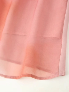 Détail de robe en mousseline tie-dye rose montrant la finition de l'ourlet double couche