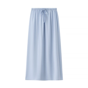 Detail view of the light blue silk texture and elastic drawstring waistband on the maxi skirt