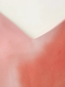 Détail du décolleté en V sur robe tie-dye avec dégradé rose corail et texture satinée