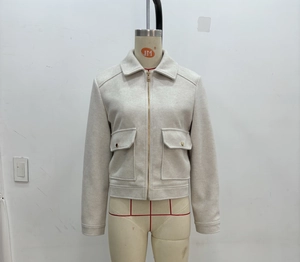 Detail of off-white tweed jacket featuring golden zipper and front square flap pockets