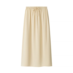 Detail of the elastic waistband and drawstring knot on a beige tiered midi skirt