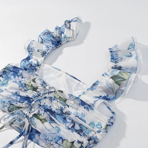 Detail of floral butterfly crop top with ruffled straps and adjustable drawstring front