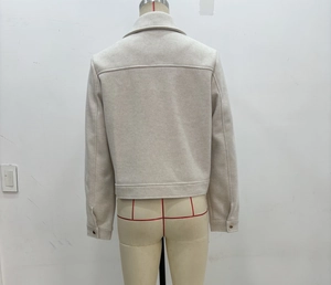Rear view of cream-colored tweed cropped jacket with collar and hem details
