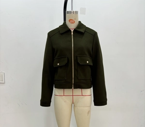 Detail of dark green tweed jacket featuring front metal zipper and large flap pockets