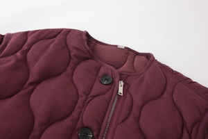 Detail of burgundy quilted jacket with round collar and metal zipper closure