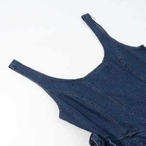 Detailed view of dark blue denim dress with contrast stitching and sturdy shoulder straps