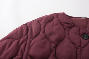 Close-up of wine red quilted jacket featuring crew neck design and wave stitching details