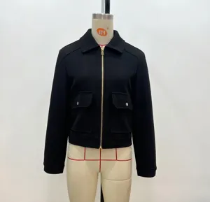 Detail of a black cropped tweed jacket with large flap pockets and silver zipper closure