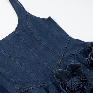 Detailed close-up of dark blue denim dress featuring an exquisite 3D floral accent