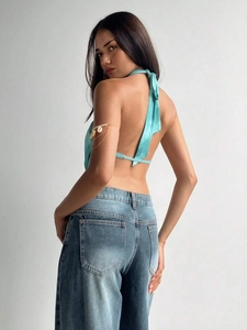 Detail of lake blue satin halter top featuring open back design and silk-like glossy finish