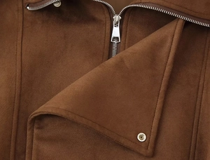 Detail of silver zipper and snap button on dark brown faux suede jacket