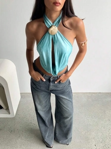 Detail of light blue satin halter top featuring gold shell metal buckle and draped neckline