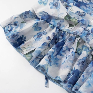 Detailed macro view of the blue floral and butterfly print with ruffled fabric edges