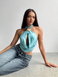 Detail of light blue satin halter top featuring a decorative gold oval metal buckle