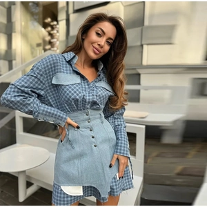 Detail of blue plaid shirt and asymmetrical denim skirt set with metallic buttons