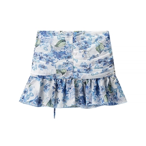 Detail of floral printed mini skirt featuring ruched fabric and tiered ruffle hem design
