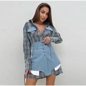 Détail de la chemise à carreaux bleue avec poche denim et jupe en jean asymétrique taille haute