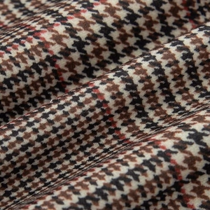 Close-up detail of houndstooth plaid fabric texture on a padded bomber jacket
