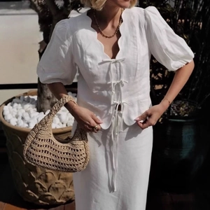 White vacation two-piece set featuring puff sleeve tie-front top and long skirt in cotton linen