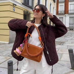 Quilted round neck jacket with drawstring paired with orange leather handbag and bear charm
