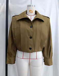 Detail of army green short trench coat featuring large lapels and shoulder epaulets