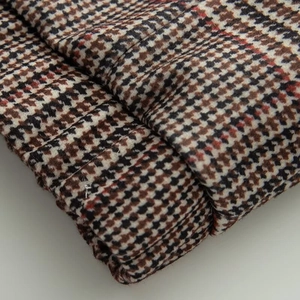 Detailed macro view of the houndstooth pattern mixed fabric on a bomber jacket sleeve