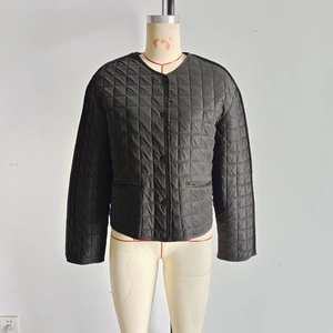 Detail of black quilted jacket featuring round neck and classic square stitching texture