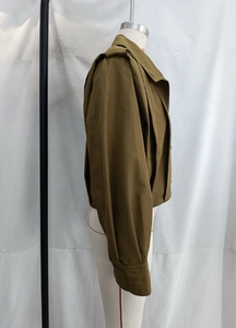 Side view of olive green cropped jacket with pleated sleeves and utility details on a mannequin
