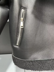 Détail d'une veste en similicuir noir avec fermeture éclair argentée et doublure en polaire