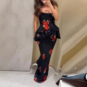 Close-up of black floral maxi dress featuring red rose prints and tiered peplum ruffles