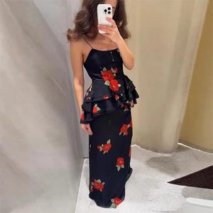 Detail of floral black maxi dress with red rose print and elegant peplum waist ruffles