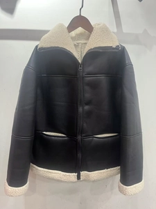 Close-up of black faux leather jacket with white faux shearling collar and zipper details