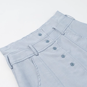 Détail du short taille haute bleu clair avec texture lin et fermeture à plusieurs boutons