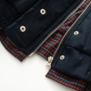 Detail of metal zipper and plaid lining on a navy Harrington jacket for women