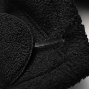 Détail de la texture en cuir PU noir et de la doublure en laine sherpa épaisse
