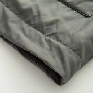 Detail of dark olive green parka featuring horizontal quilting and high-quality stitching