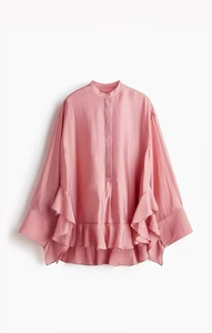 Detail of pink loose-fit satin shirt with stand collar and ruffled hem layering