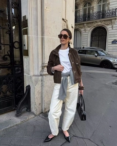 Détail de la veste en daim marron avec pantalon blanc et pull en maille accessoire