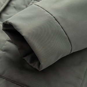 Close-up of high-density windproof green parka fabric with premium stitching details