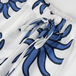Detailed view of elastic drawstring waist on blue floral print trousers with premium stitching