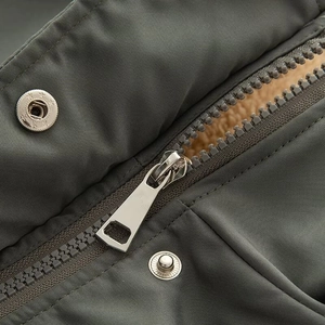 Detailed macro view of the thick fleece lining and durable metal zipper on the parka coat