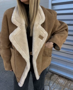 Detail of vintage brown shearling jacket featuring thick cream fleece lining and large lapels