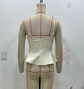 Detailed back view of ivory peplum top with thin straps and deep U-shaped cut-out