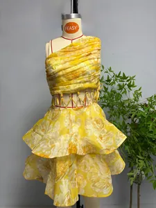 Détail de la robe à fleurs jaune avec découpe à la taille et anneau métallique