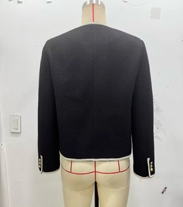 Detail view of tweed jacket back with white braided trim and gold embossed buttons