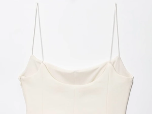 Close-up of white spaghetti strap top with sleek fabric and side zipper detail