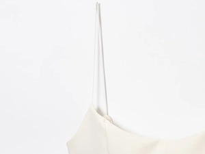 Close-up of slim straps and satin fabric texture on a cream camisole top